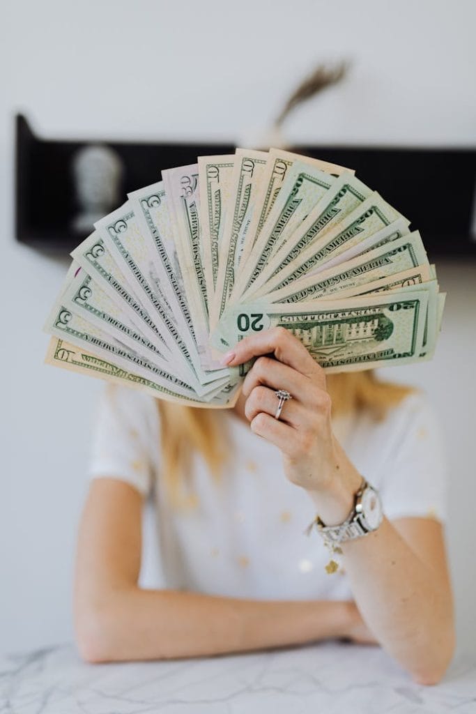 person-holding-fan-of-us-dollar-bills-4968649 A person holding a fan of US dollar bills, symbolizing wealth and financial success.