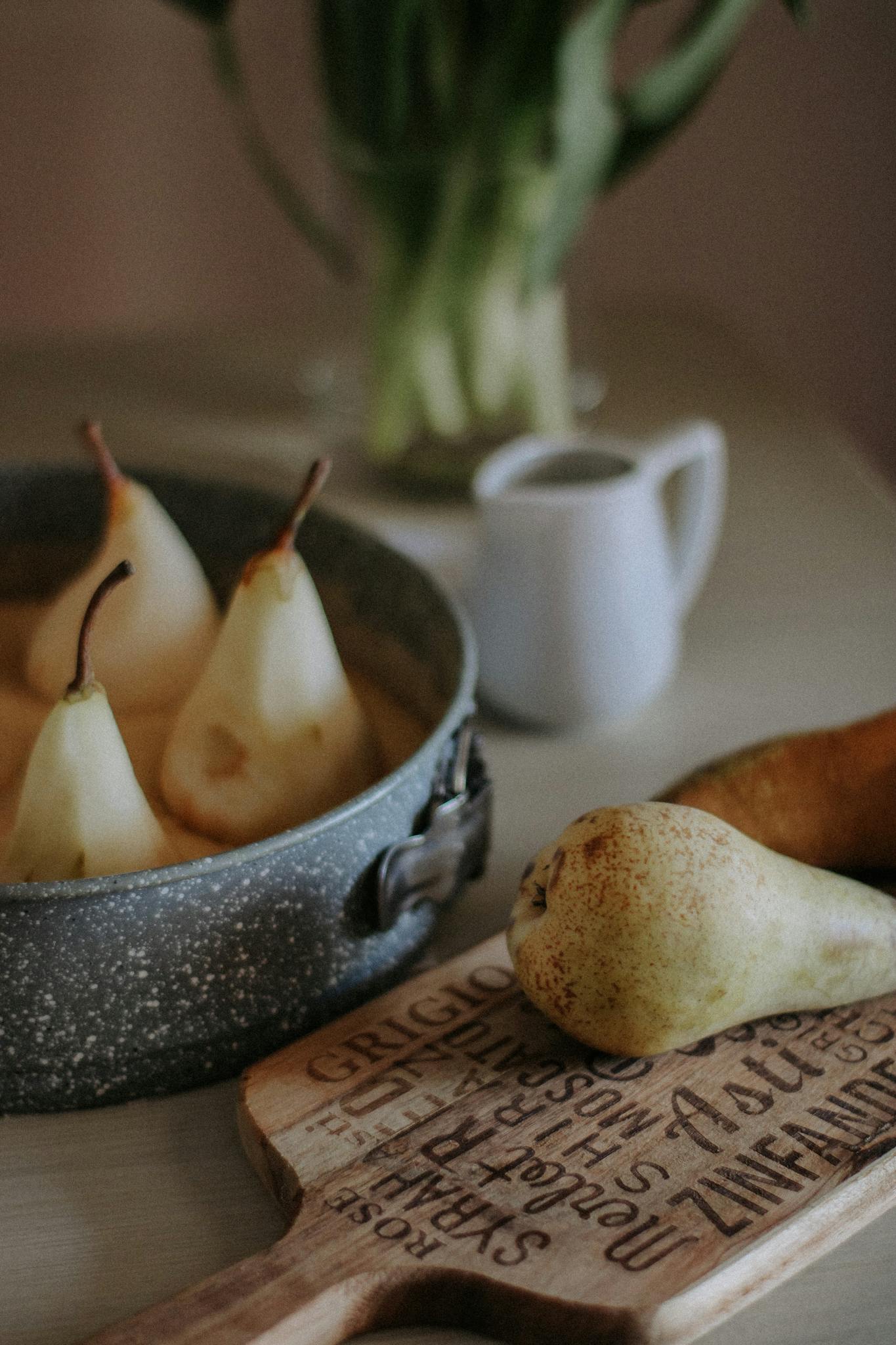 A cozy kitchen scene with ripe pears, a baking tray, and rustic details.